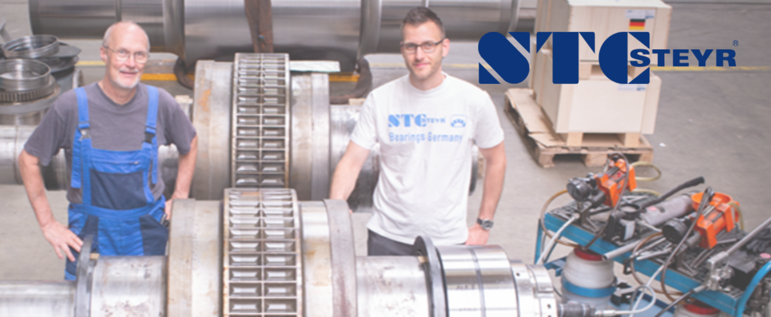 STC-Steyr technicians showcasing the precision assembly of a heavy-duty industrial roller bearing for a rolling mill application.