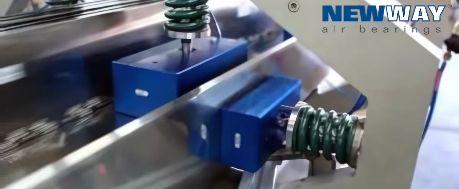 NewWay Air Bearings' blue, spring-loaded blocks on a precision guide, demonstrating frictionless motion for industrial machinery.